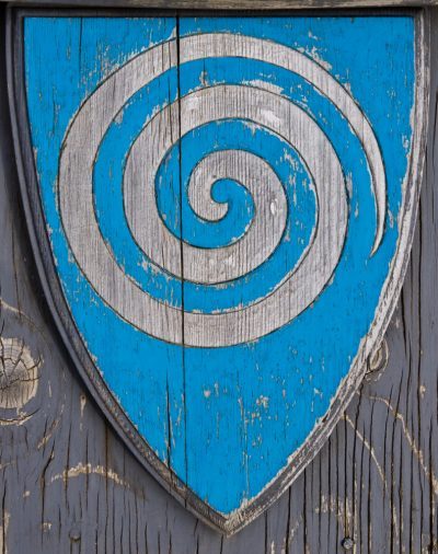 a,wooden,shield,bears,the,spiral,symbol,of,a,whirlpool