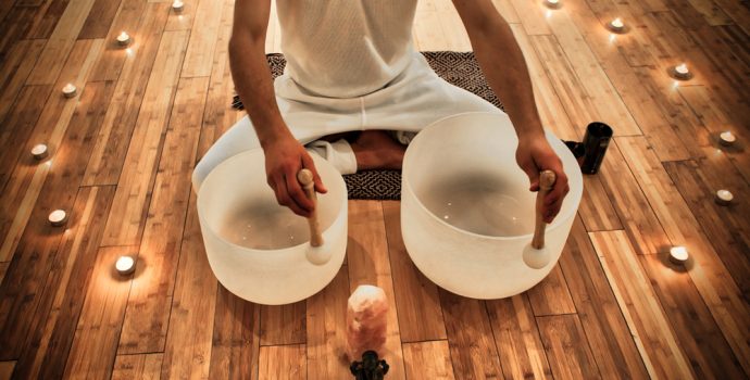 young,man,playing,crystal,bowls,as,part,of,a,meditative