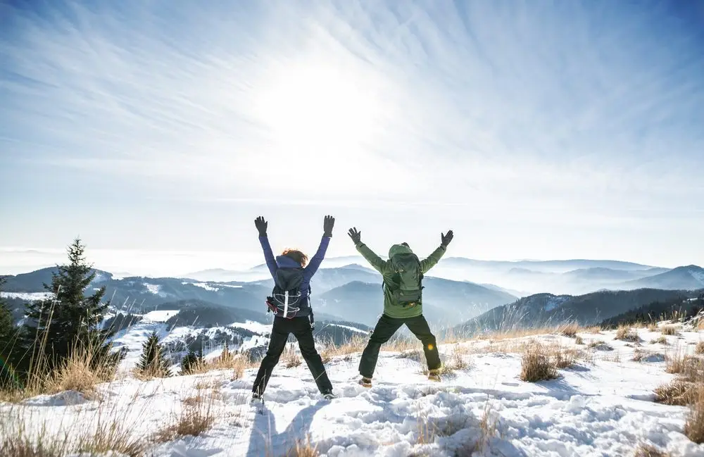 rear,view,of,senior,couple,hikers,in,snow covered,winter,nature,